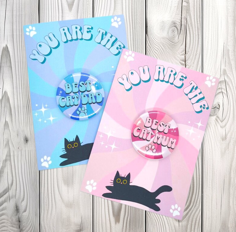 Picture shows two greeting cards with badges attached which say best cat mum and best cat dad, the perfect gift for mother's day or father's day 