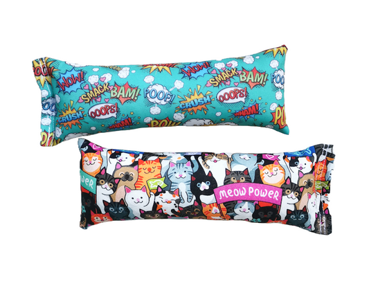 two high strength catnip kickers in bright fabrics, one featuring cartoon pows and one featuring cats holding a banner that says "meow power"