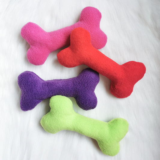 Picture shows four fleece dog squeaky bone toys in pink, red, purple and green