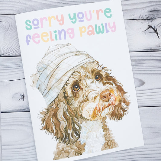 a greeting card with a dog on the front which has a bandage wrapped round its head, the card reads sorry you're feeling pawly, a funny pun to bring positivity to stressful times for dog owners