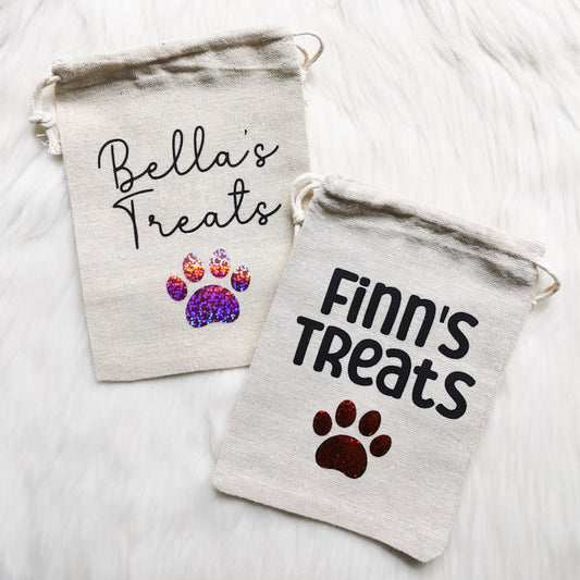 two dog treat pouches, both personalised with the dogs names, one is more feminine and one is more masculine, great gift for dog walkers