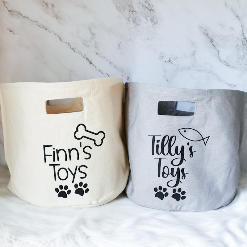 photo shows two pet storage totes, one which says finn's toys and the other says tilly's toys, these storage totes are great for storing pet toys or accessories in and would make a great pet friendly homeware gift for any cat or dog lover