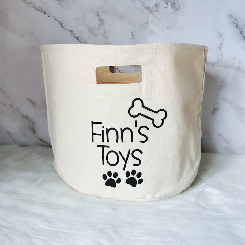 photo shows one singular pet storage tote with the words finn's toys on, this tote would be perfect for any dog lover to store their dogs toys in