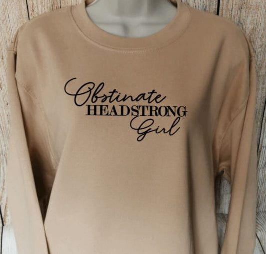 a sweatshirt for book lovers and feminists in the colour nude with the words obstinate headstrong girl on from pride and prejudice