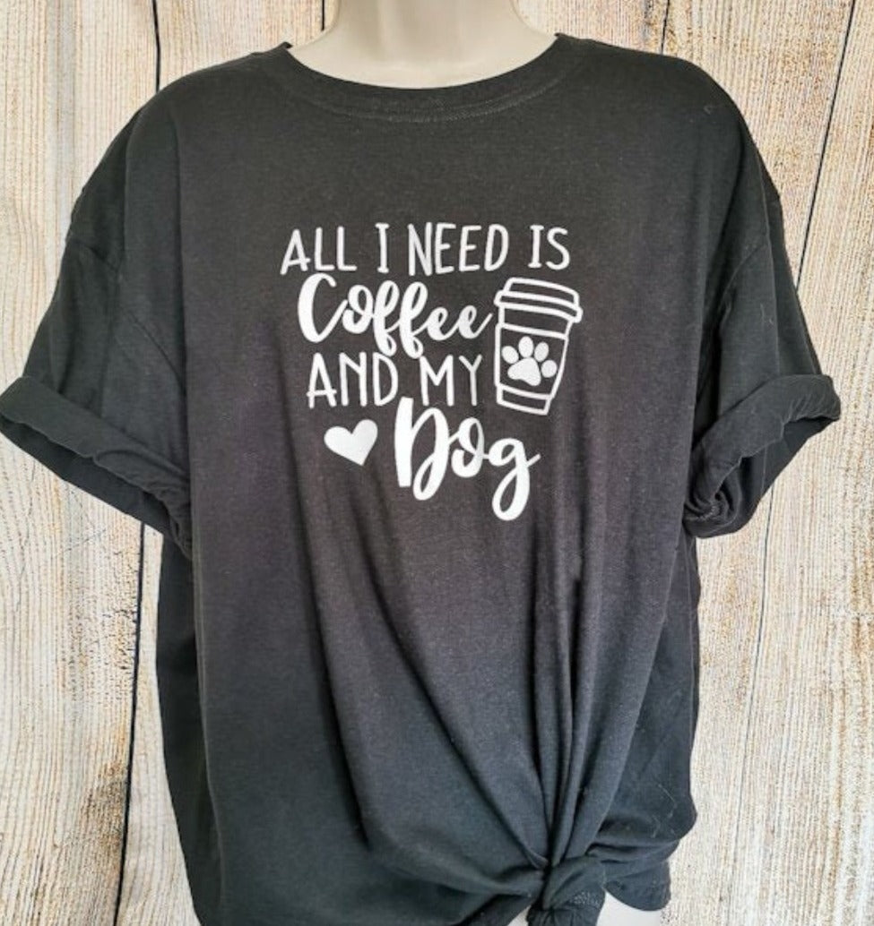 A photo of a tshirt that says all I need is coffee and my Dog, the tshirt itself is black with white text, this tshirt is perfect gift for any dog lover