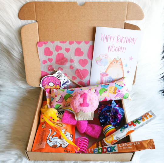 Pink cat birthday gift box with a personalised felt cupcake, card, catnip kicker, assortment of treats and toys which cats will love.