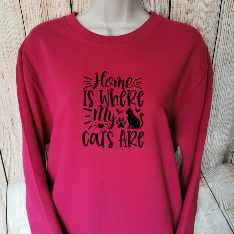 a sweatshirt for cat lovers in the colour cranberry which says home is where my cats are