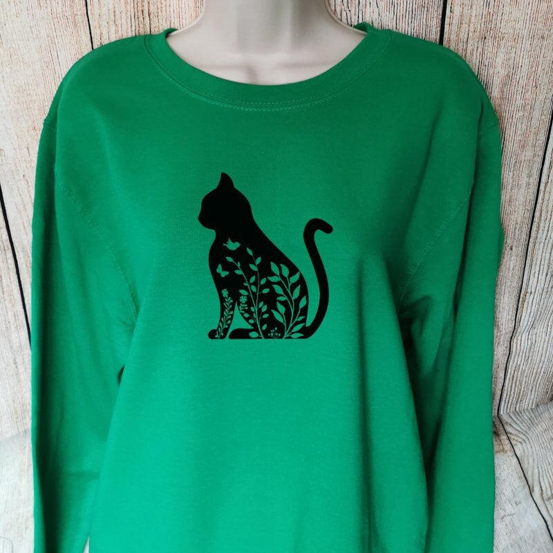 a green sweatshirt for cat lovers with the image of a floral cat sat posed