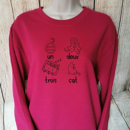 a sweatshirt for cat lovers in the colour cranberry which says un deux trois cat on